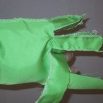 Glove body halfway done, showing fingers partially complete.