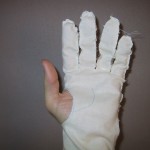 A thumbless glove cut out of muslin as a test.