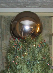 Silvery glass sphere on the top of a christmas tree