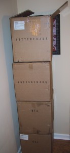 Four pottery barn boxes stacked on top of each other