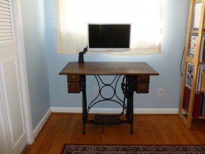 Swing arm monitor over a cast iron sewing machine base table