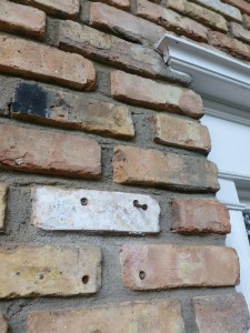 Four holes in the brick, and the ends of the lamp cord poking over the door frame