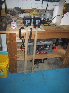 tubes being held up against a workbench by supports with weights on top